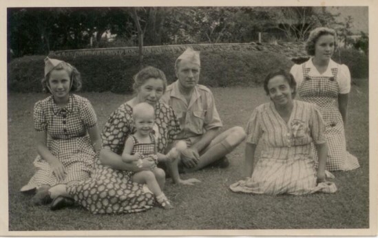Family photo taken on Java during the occupation. Dee Kiesling on the right in a bibbed gingham dress.
